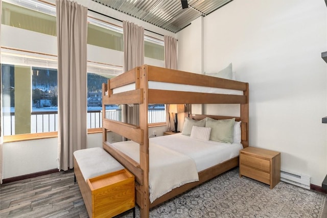 bedroom featuring hardwood / wood-style floors and a baseboard radiator