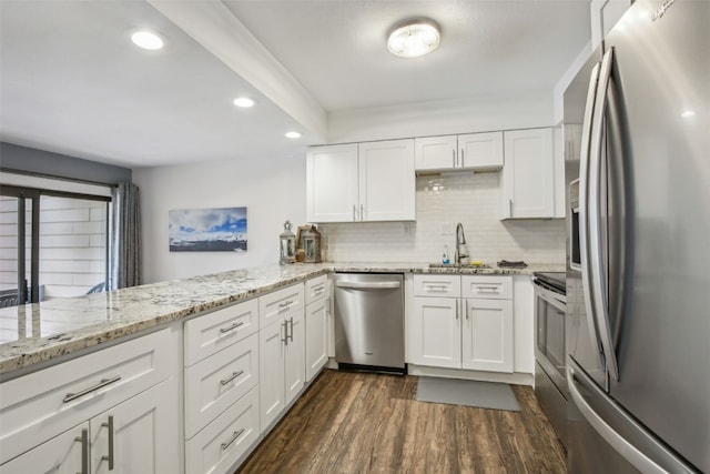 kitchen featuring kitchen peninsula, sink, dark hardwood / wood-style floors, appliances with stainless steel finishes, and white cabinetry