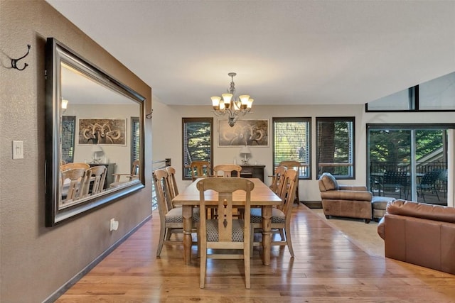 dining area with hardwood / wood-style floors and an inviting chandelier