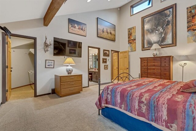 bedroom with beam ceiling, ensuite bathroom, high vaulted ceiling, and light colored carpet