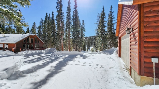 snowy yard featuring a garage