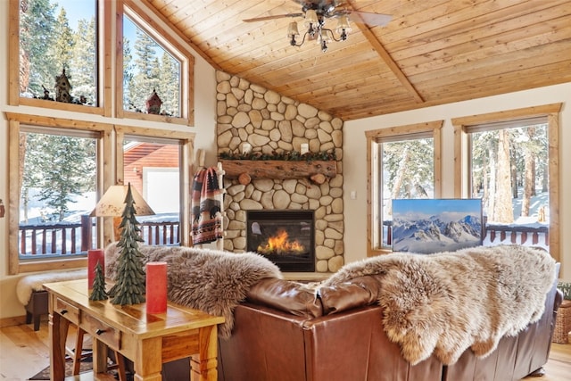 living room featuring vaulted ceiling, a stone fireplace, wood finished floors, and wood ceiling