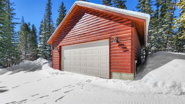 snow covered garage with a detached garage