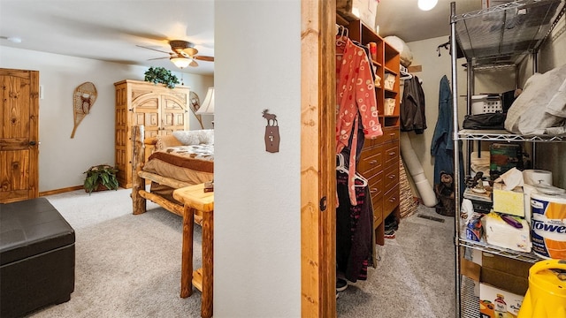 walk in closet with carpet floors and a ceiling fan