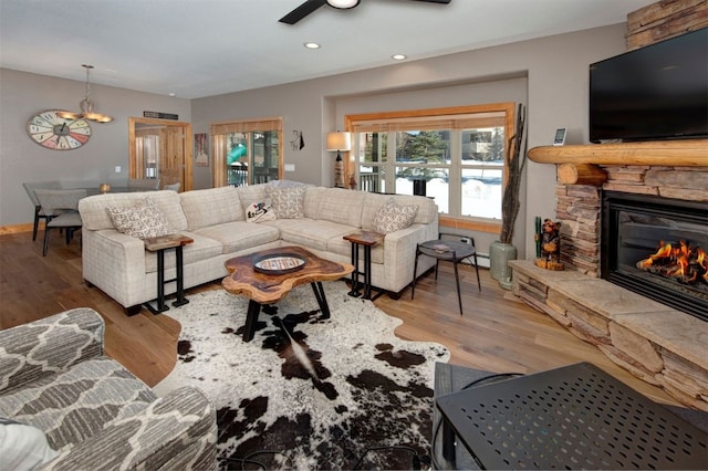 living area featuring light wood-style flooring, a fireplace, ceiling fan, and recessed lighting