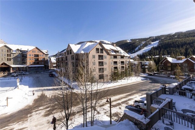 snow covered building featuring a mountain view