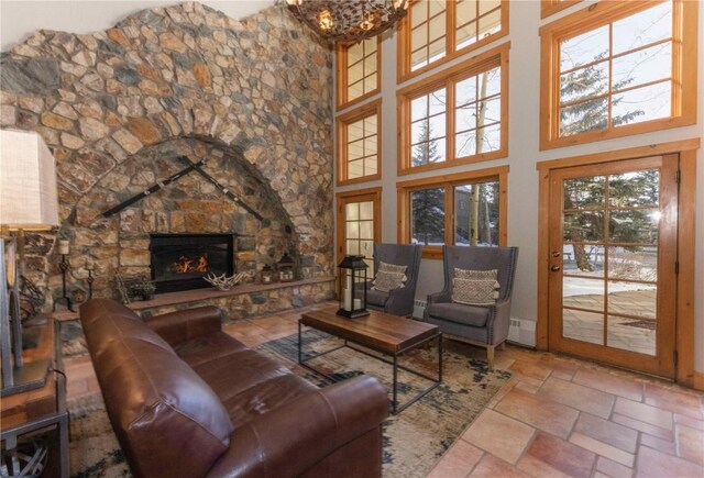 living room with a stone fireplace and a high ceiling