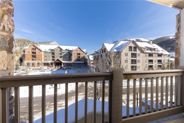 snow covered back of property with a mountain view