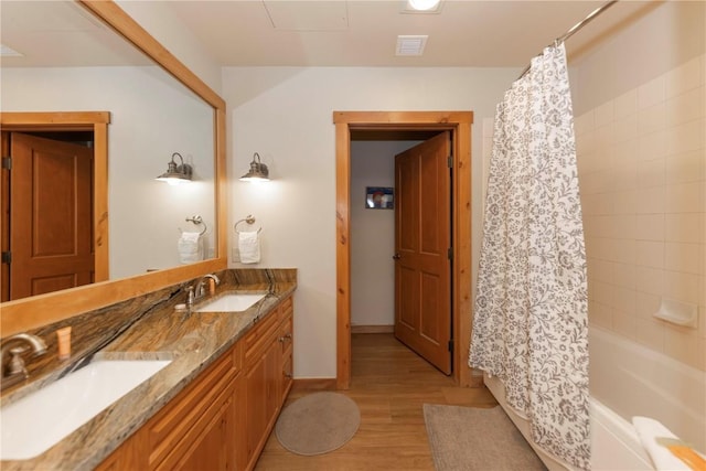 bathroom featuring wood-type flooring, vanity, and shower / bath combination with curtain