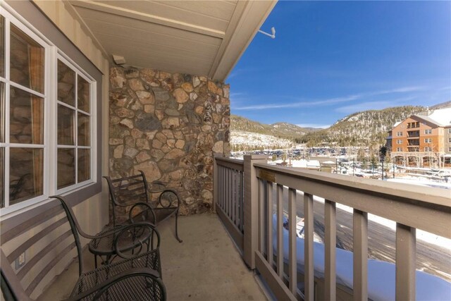 snow covered back of property with a mountain view