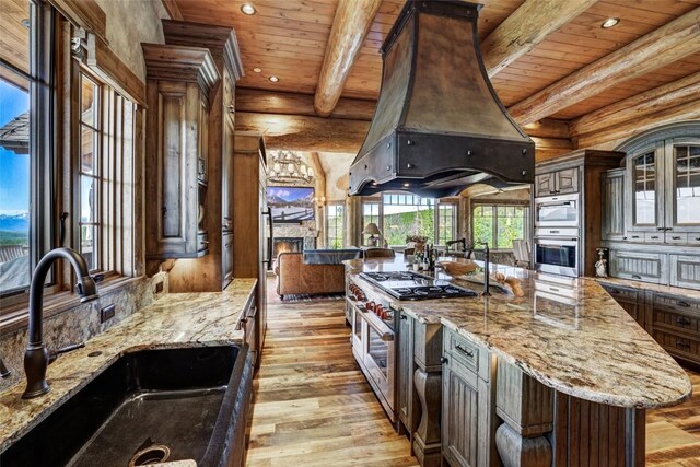 kitchen featuring premium range hood, a mountain view, a center island, and dark brown cabinetry