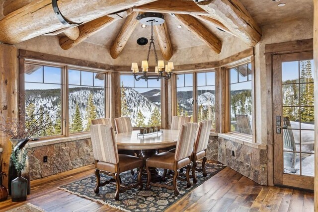 sunroom with a notable chandelier, a high end fireplace, and lofted ceiling with beams