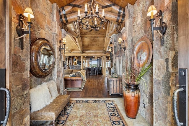 hall with beam ceiling, wooden ceiling, a chandelier, and high vaulted ceiling