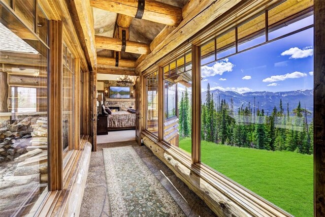 unfurnished sunroom featuring a fireplace, a mountain view, and a wealth of natural light