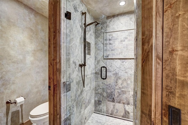 full bathroom featuring a shower stall and toilet