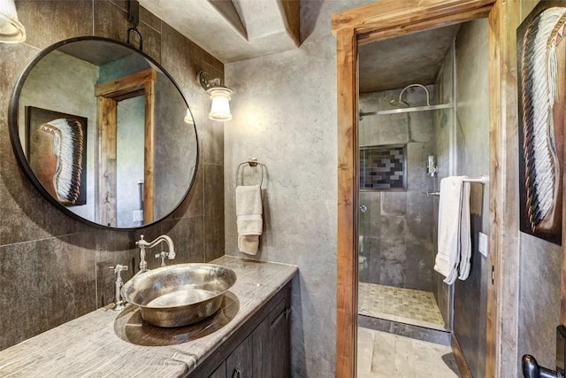 bathroom featuring a tile shower and vanity