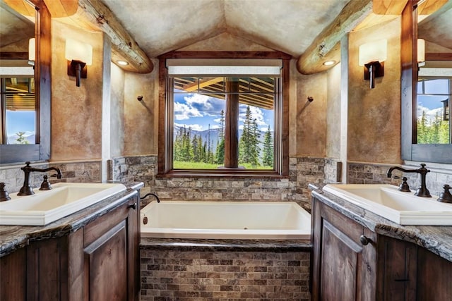 bathroom with two vanities, lofted ceiling, and a sink