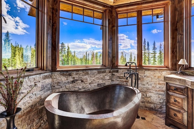 full bathroom with a soaking tub and vanity