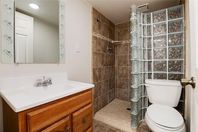 bathroom featuring tiled shower, vanity, and toilet