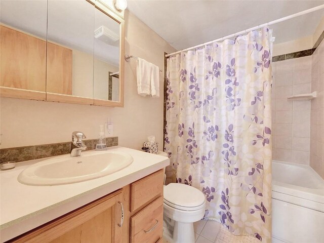 full bathroom with tile patterned floors, vanity, toilet, and shower / bath combo with shower curtain