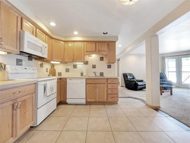 kitchen with light brown cabinets, white appliances, french doors, sink, and light colored carpet