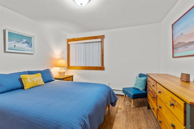 bedroom with baseboard heating and wood-type flooring