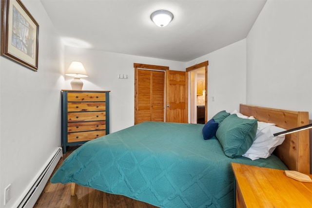 bedroom with wood-type flooring, connected bathroom, a closet, and a baseboard heating unit