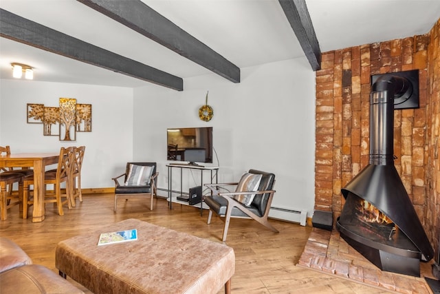 living room featuring beamed ceiling, hardwood / wood-style floors, a wood stove, and baseboard heating