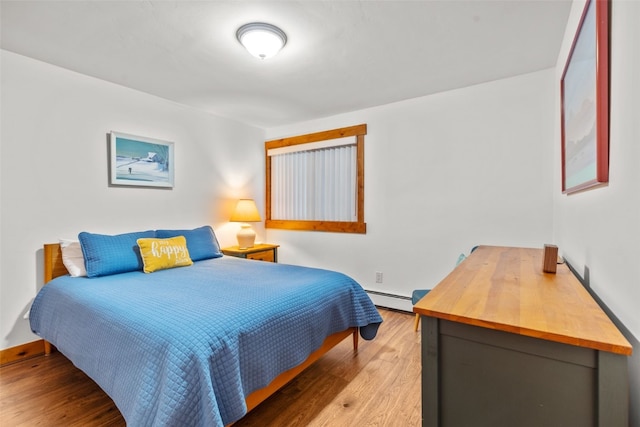 bedroom featuring light wood-type flooring and a baseboard radiator