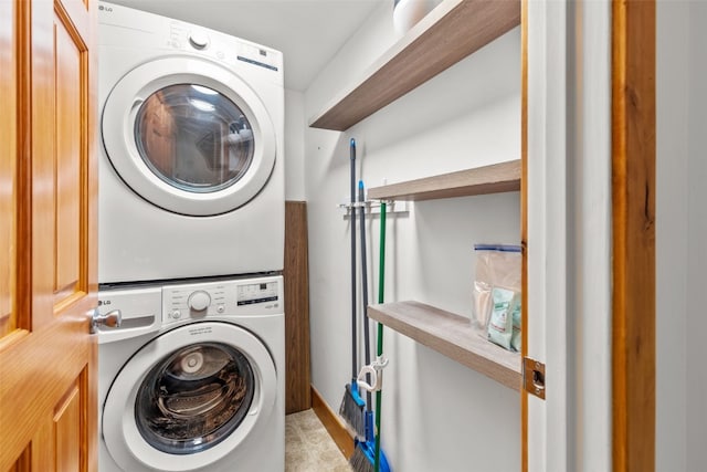 washroom featuring stacked washer / drying machine and light tile patterned flooring