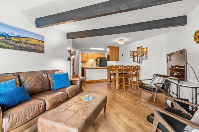 living room featuring beam ceiling and light hardwood / wood-style flooring