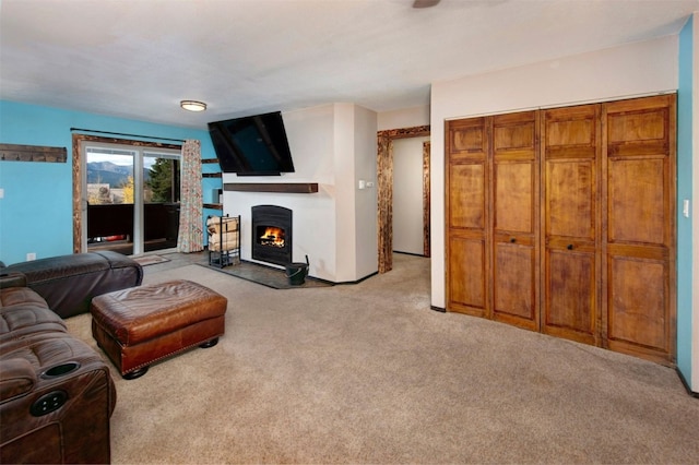 carpeted living room featuring a lit fireplace