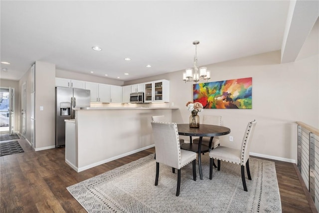 dining area with dark wood-type flooring and a notable chandelier