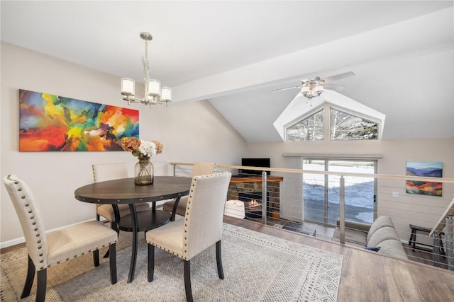 dining area featuring hardwood / wood-style floors, ceiling fan with notable chandelier, and vaulted ceiling with beams