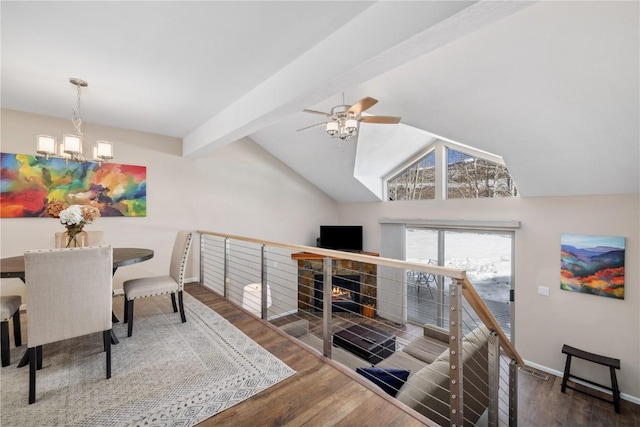 living room with ceiling fan with notable chandelier, dark hardwood / wood-style flooring, and lofted ceiling with beams