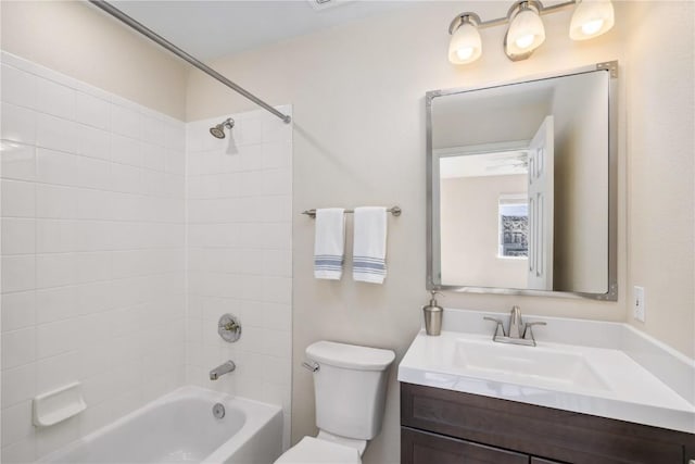 full bathroom with tiled shower / bath, vanity, and toilet