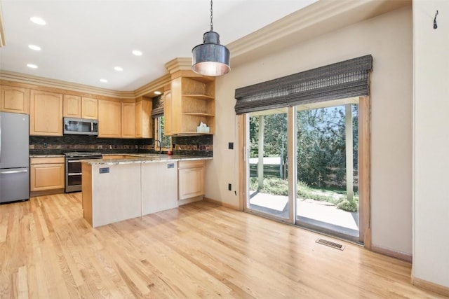 kitchen featuring kitchen peninsula, stainless steel appliances, light brown cabinets, decorative light fixtures, and light hardwood / wood-style flooring