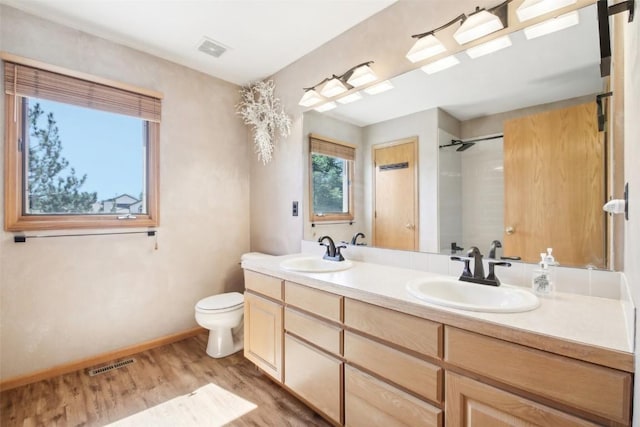 bathroom featuring vanity, toilet, a shower, and wood-type flooring