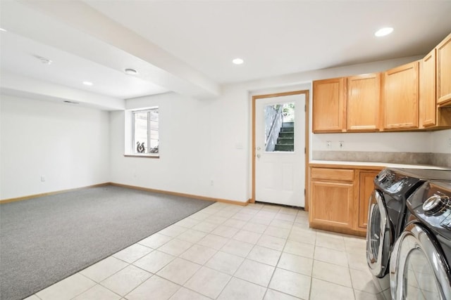 kitchen with light brown cabinetry, light colored carpet, and washer and clothes dryer