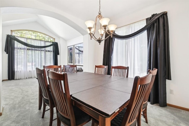 carpeted dining space featuring a chandelier and lofted ceiling