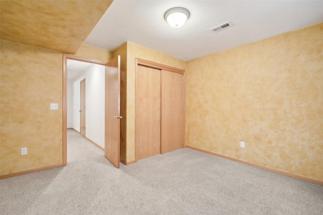 unfurnished bedroom featuring a closet and light colored carpet