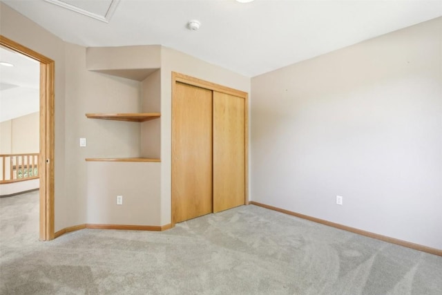 unfurnished bedroom featuring light carpet and a closet