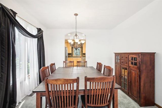 carpeted dining area with sink and an inviting chandelier