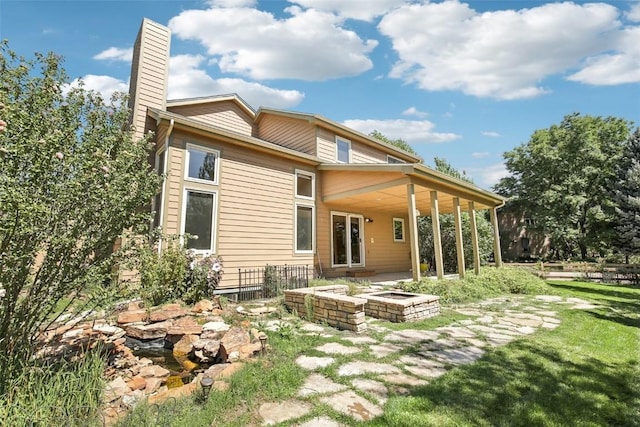 rear view of property with a lawn