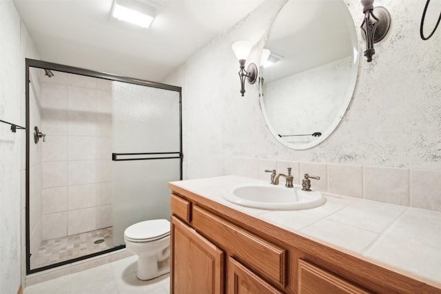 bathroom featuring tile patterned flooring, vanity, toilet, and walk in shower