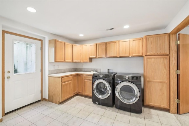 washroom featuring washing machine and clothes dryer, sink, and cabinets