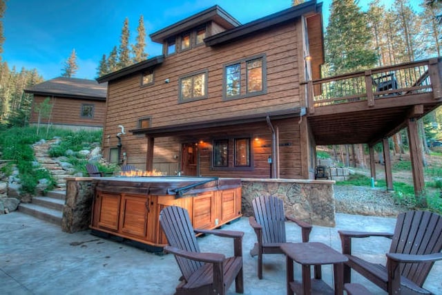 rear view of house with a patio, a hot tub, and a deck