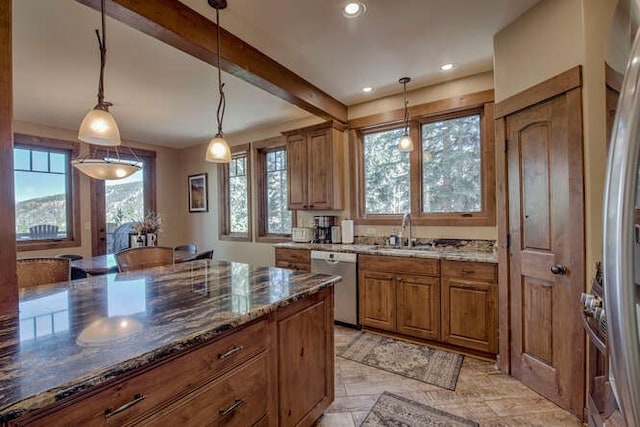 kitchen featuring pendant lighting, sink, stainless steel dishwasher, dark stone countertops, and beamed ceiling