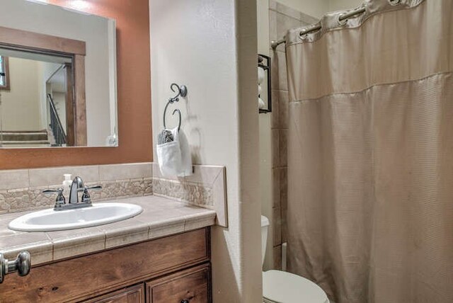 bathroom featuring decorative backsplash, a shower with curtain, vanity, and toilet