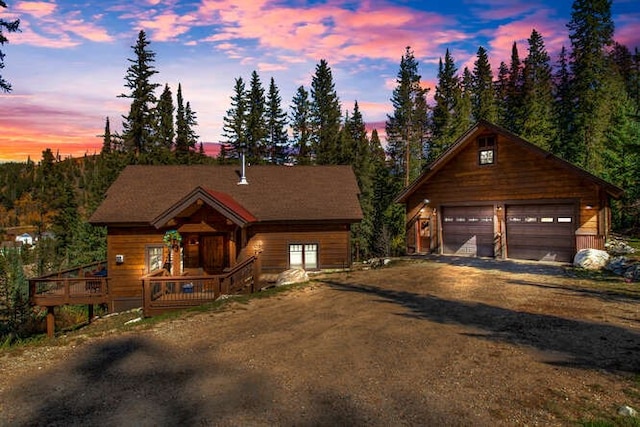 log home with a garage and an outdoor structure